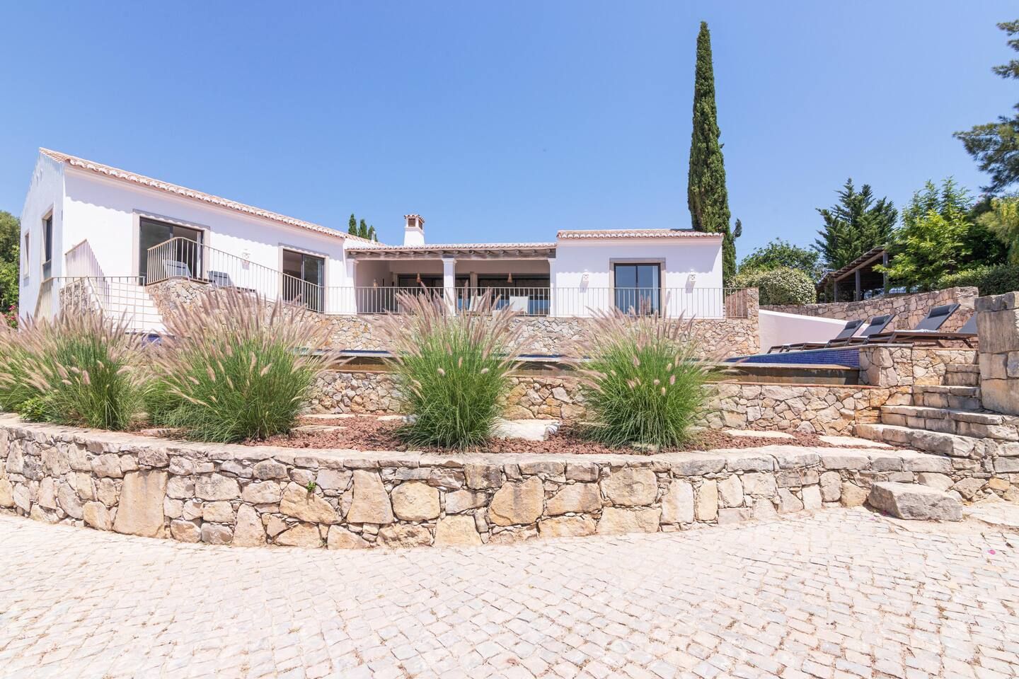 The villa's exterior, showing the house and pool terraces